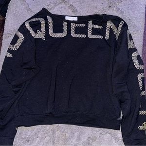 Black, gold sweater. The sweater is from Nicki Minaj’s collection and it is a XL